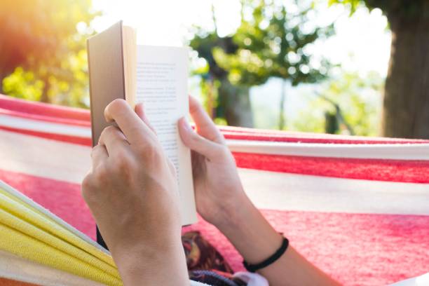istock hands with the book reading in the hammock 1132312684