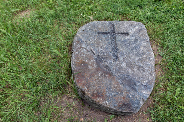 istock Stone lying on green grass with cross embossed on it 1132312899