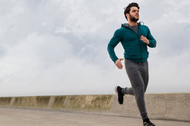 istock Active Young Man Jogging on A Foggy Winter Day 1132314008