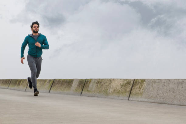 istock Active Young Man Jogging on A Foggy Winter Day 1132314095