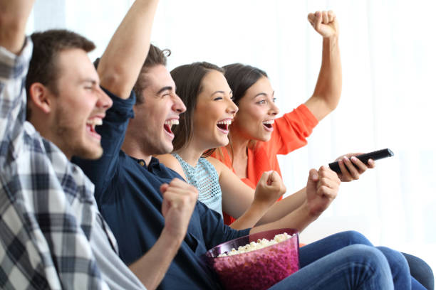 istock Excited friends watching tv celebrating success 1132314284