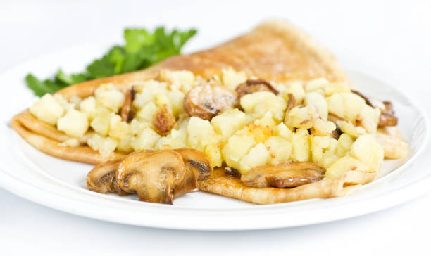 istock Thin delicious pancake with potatoes and mushrooms on white 1132314442