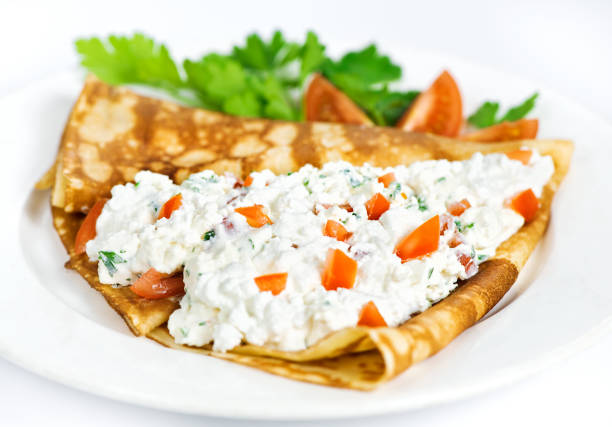 istock Thin delicious pancake with cottage cheese and tomatoes on white 1132315234