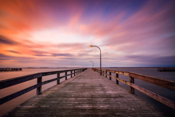 istock Beautiful colorful clouds streaking over a pier at sunset. 1132315297