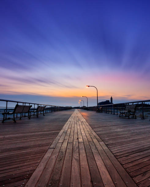 istock Moody empty boardwalk at dusk. Dramatic scene with blue tones and wispy sweeping clouds 1132315468