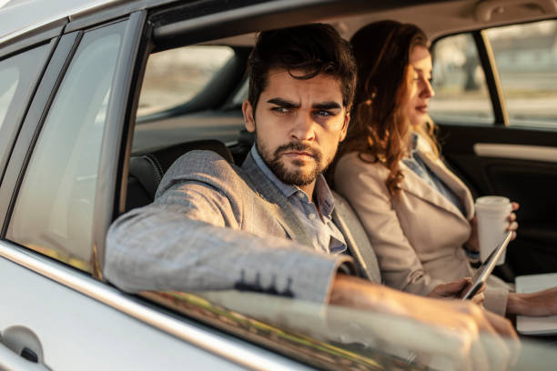 istock Handsome man sitting in a car with tablet computer 1132315771
