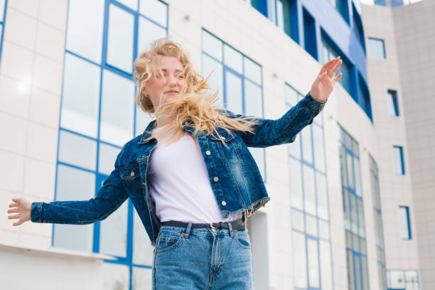 istock Girl, jeans and jacket, fun, close up, building background 1132315870