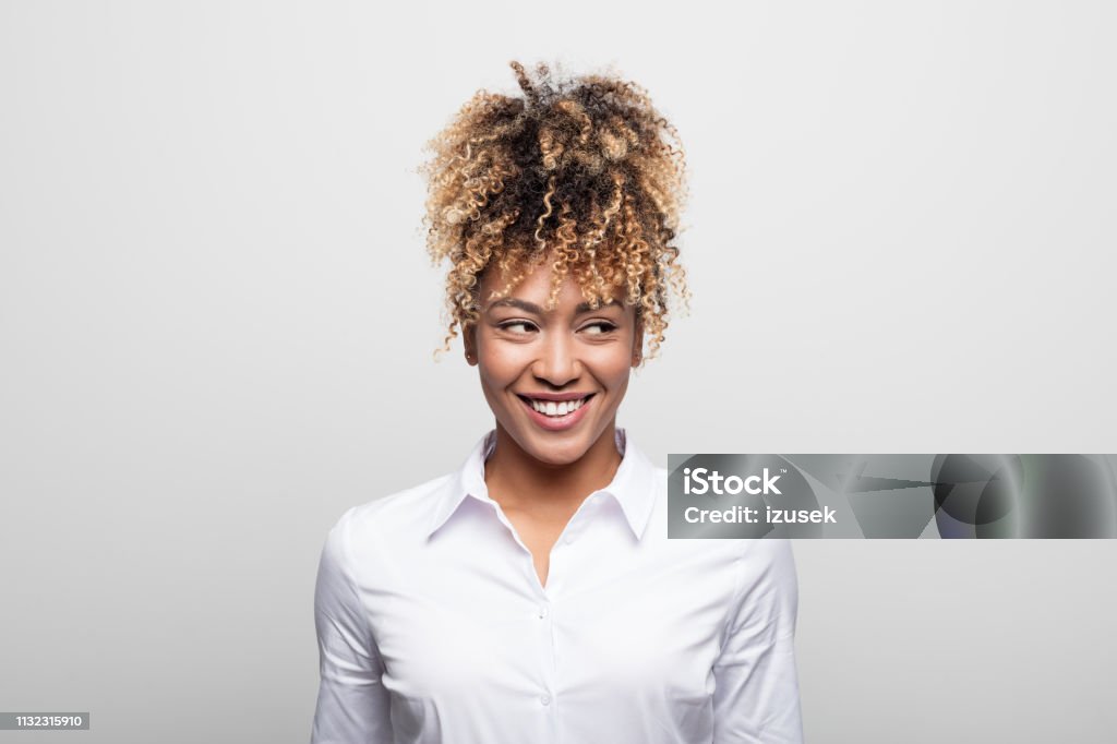 Mid adult businesswoman smiling while looking away Close-up of businesswoman smiling while looking away. Attractive mid adult female manage is wearing businesswear on white background. She is having curly blond hair. White Background Stock Photo