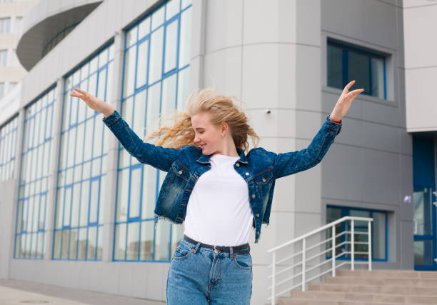 istock Girl, jeans and jacket, fun, close up, building background 1132316147
