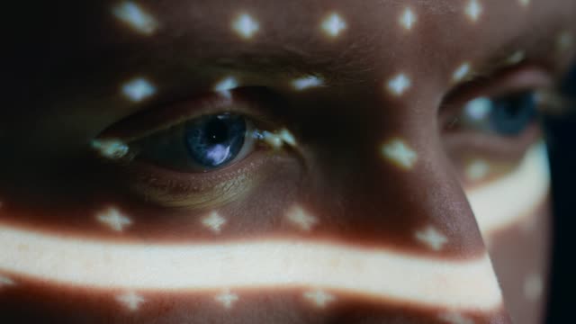Biometric Facial Recognition Scanning of Blue Eye's Iris. Futuristic Concept: Projector Identifies Individual by Illuminating Face by Dots and Scanning with Laser. Close-up Shot