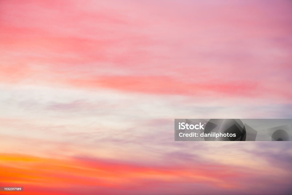 Sunset sky with pink orange light clouds. Colorful smooth blue sky gradient. Natural background of sunrise. Amazing heaven at morning. Slightly cloudy evening atmosphere. Wonderful weather on dawn. Atmospheric Mood Stock Photo