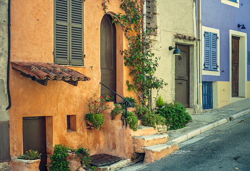 Row of colorful facades in a street of Cagnes-Sur-Mer, France. Some colors and details were digitally altered.