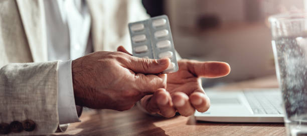istock Businessman taking medical pills in the office 1132319632