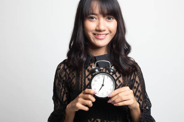 istock Young Asian woman smile with a clock. 1132321823