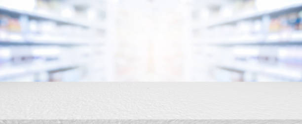 абстрактные размытые аптеки прохода полки распределения фона с белым бетонным столешницей счетчик для медицинской фармацевтической бизн� - фармацевтической стоковые фото и изображения