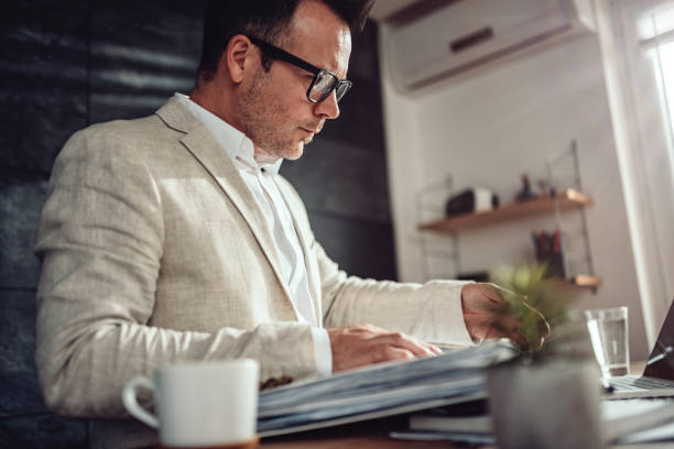 istock Businessman searching files in ring binder folder 1132323636