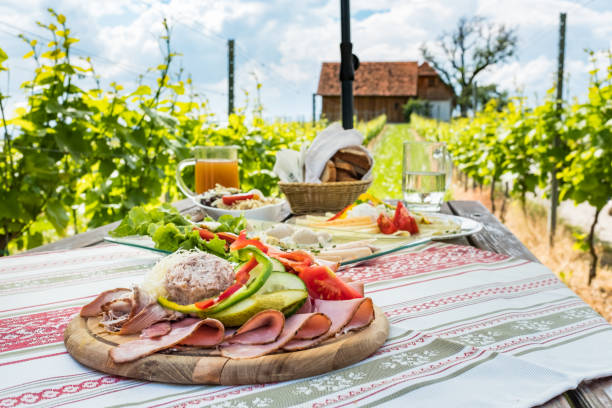 Brettljause, cold plate with meal on wooden table in vineyard