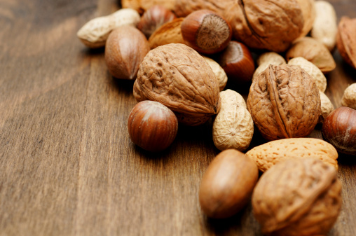 mixed festive seasonal nuts against dark oak