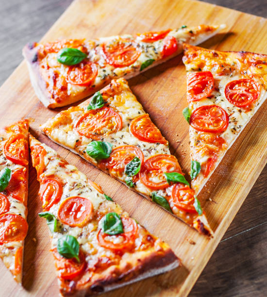 istock Pizza with Mozzarella cheese, Tomatoes, pepper, Spices and Fresh Basil. Italian pizza. Pizza Margherita or Margarita on wooden table background 1132329761
