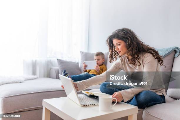 Busy Mother Working From Home With Son Stock Photo - Download Image Now - Working At Home, Child, Mother
