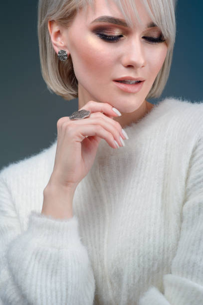 istock The blonde with a beautiful ring and earrings posing in the studio on blue background 1132330590