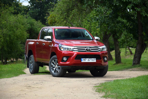 Red pick-up Toyota Hilux on the road Poznan, Poland - July 7th, 2016: Red pick-up Toyota Hilux parked on the road. The Hilux is one of the most popular pick-up vehicles in the world. toyota hilux stock pictures, royalty-free photos & images