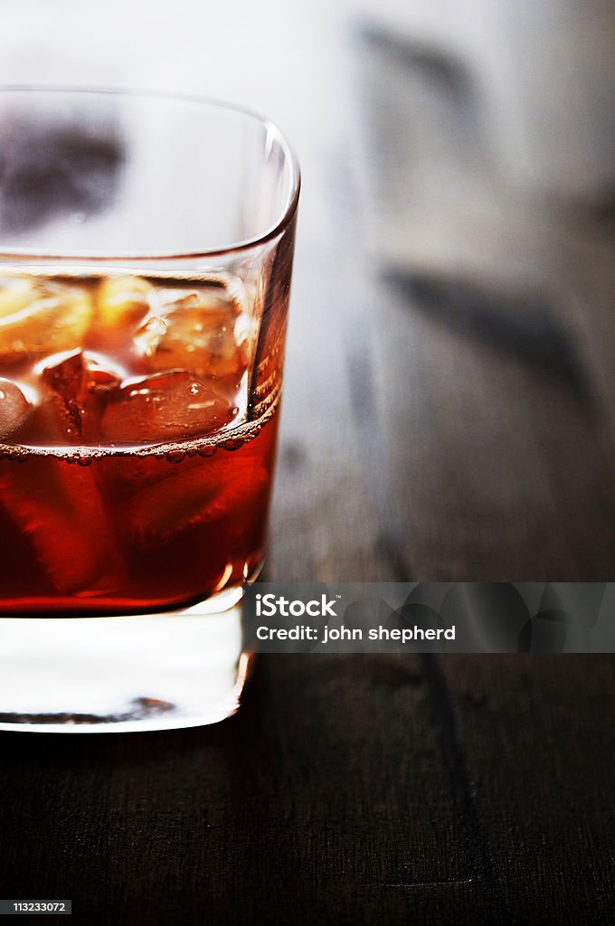 glass of iced bourdon whiskey glass of iced bourdon whiskey against dark oak backlit room for copy Alcohol - Drink Stock Photo