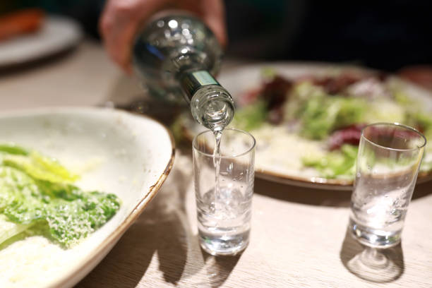 istock Man filling glasses with vodka 1132331455