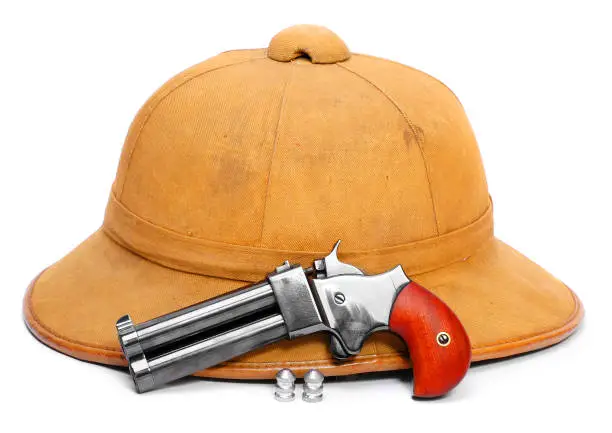 Photo of Self defense Derringer hand gun and pith helmet. Civil weapon for good feel in dangerous situations.