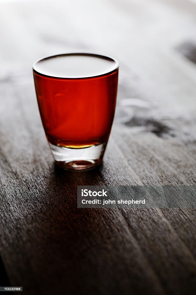 whiskey scozzese, bourbon Bicchierino da shot controluce contro quercia scura - Foto stock royalty-free di Bicchierino da shot