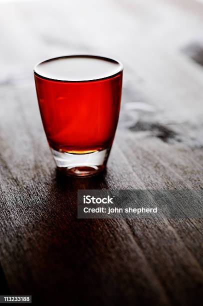 Whiskey Scozzese Bourbon Bicchierino Da Shot Controluce Contro Quercia Scura - Fotografie stock e altre immagini di Bicchierino da shot