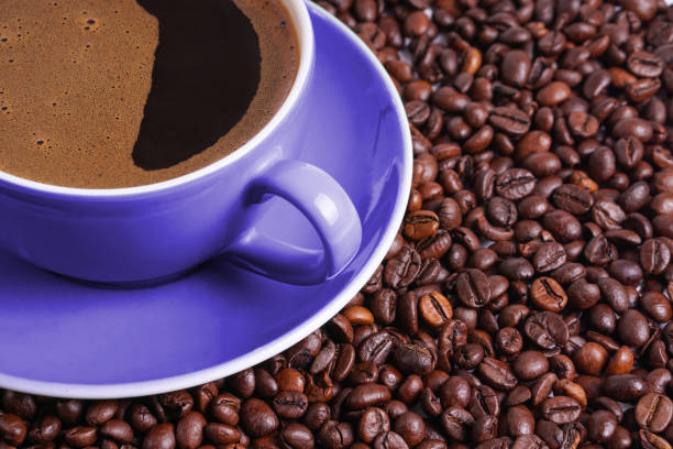 istock Coffee in purple cup on table surrounded with coffee beans 1132332523