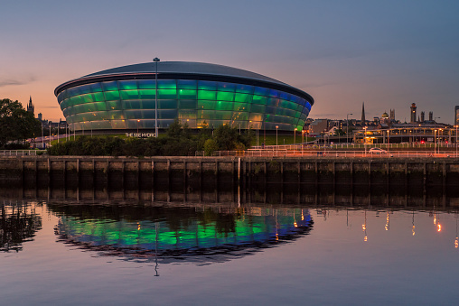 Glasgow, Scotland - September 20 2016: The SSE Hydro lit up in blue and green and reflected in the Clyde River at dusk