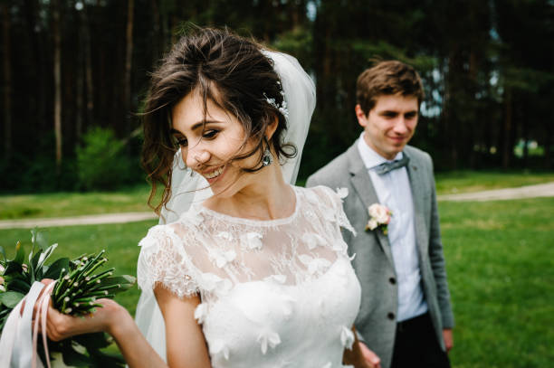 feliz novia y novio casarse en el bosque verde. ceremonia de boda. - middle human age leaf tree fotografías e imágenes de stock