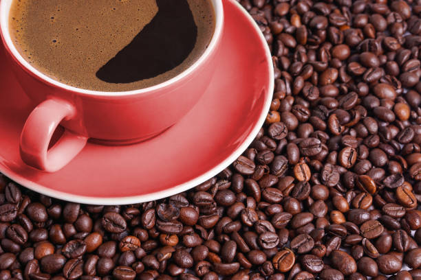 istock Coffee in red cup on a table surrounded by coffee beans. 1132333524