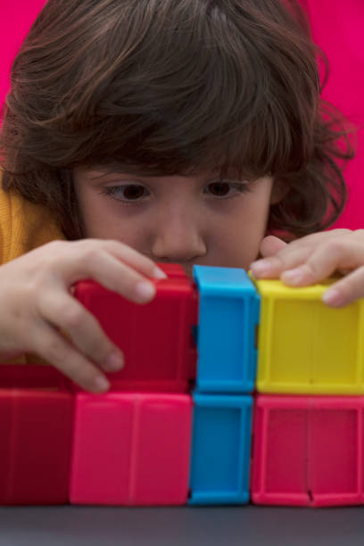 Happy child playing with Preschoolers Building Blocks.Young Boy Building With Plastic Toy Blocks.Beautiful little boy is playing with blocks.Beautiful boy playing in the playroom with educational toy blocks.