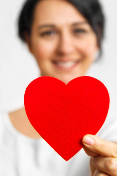 Healthy young woman holding a red heart