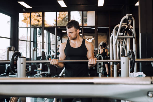 istock Young guy with muscular body with barbell in a gym 1132339936