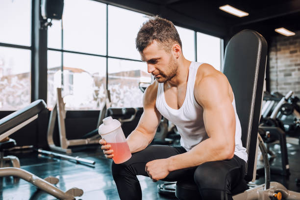 istock Young man holding energy drink in a bottle and taking a break 1132339950
