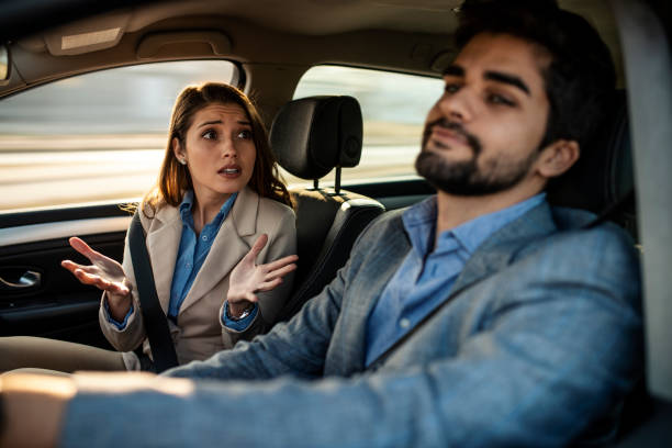 A man driving while a female passenger is fussing about