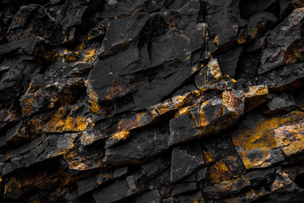 black rock background with golden / yellow color - broken stones imagens e fotografias de stock