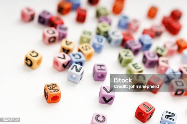 Verstreut Kantenlänge Perlen Von Alphabet Buchstaben Gegen Weiß Stockfoto und mehr Bilder von Alphabet