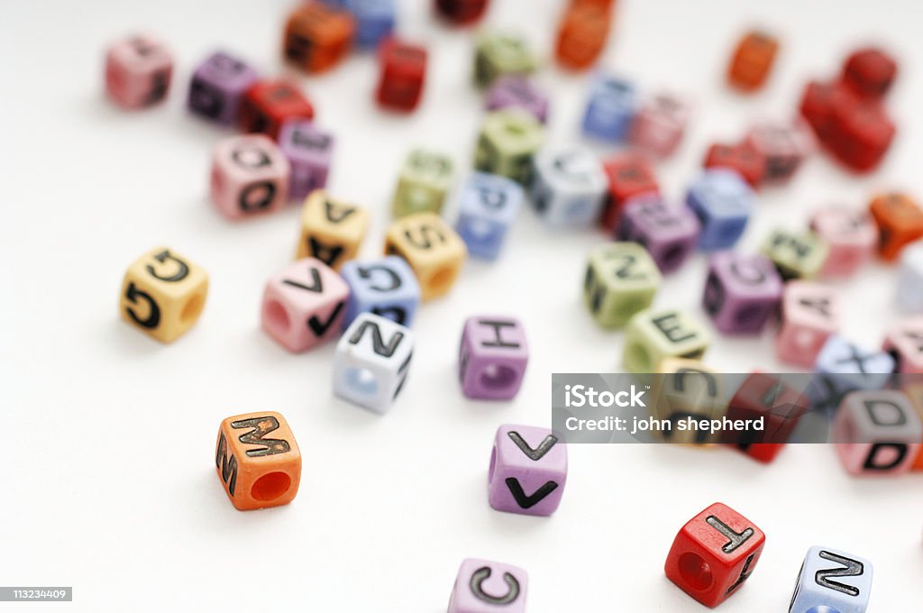 Contas de espalhadas em cubos alfabeto de letras contra branco - Foto de stock de O Alfabeto royalty-free