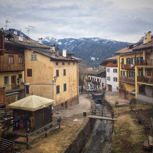 istock Cavalese, Italy bridge and small stream and mountain in background 1132344464