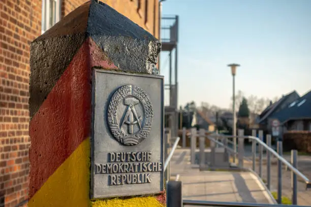 Photo of a pole with the coat of arms of the GDR stands in a village