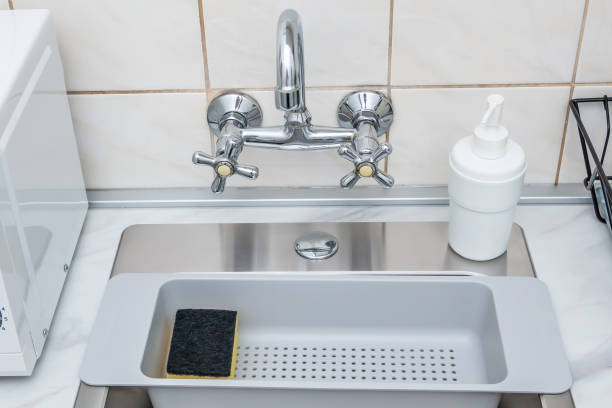istock Modern kitchen sink and faucet, plastic sponge drying rack and dish washing liquid bottle. 1132346533