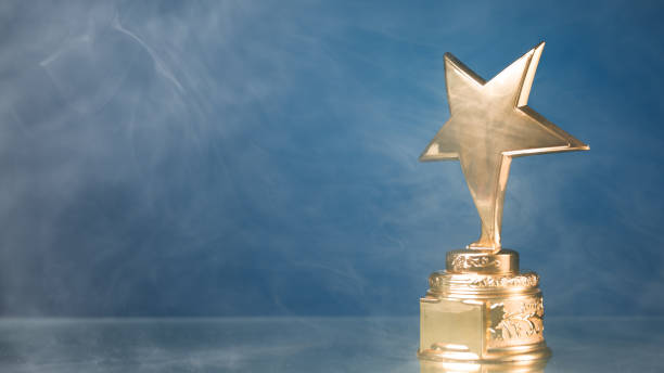 istock gold star trophy in smoke, blue background 1132348964