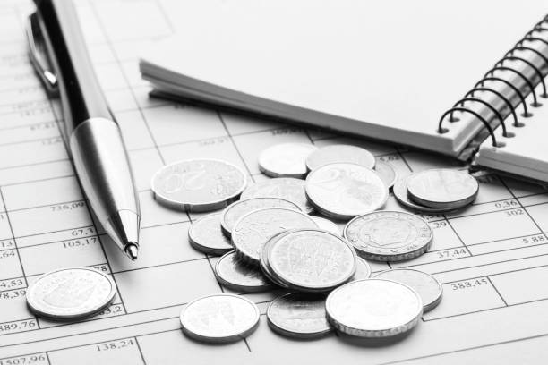 pile de pièces euro euro sur la vieille table en bois noir. stylo, cahier et documents comptables avec numéros - sales manager photos et images de collection