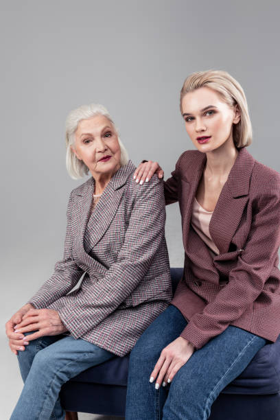 istock Good-looking young lady sitting next to her short-haired mother 1132349947