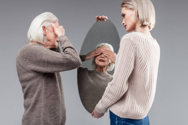 istock Grey-haired senior lady covering her eyes with both hands 1132349978